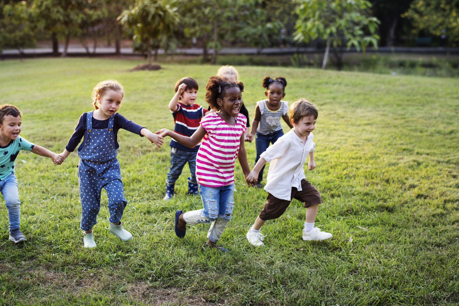 Group of children holding hands and running together